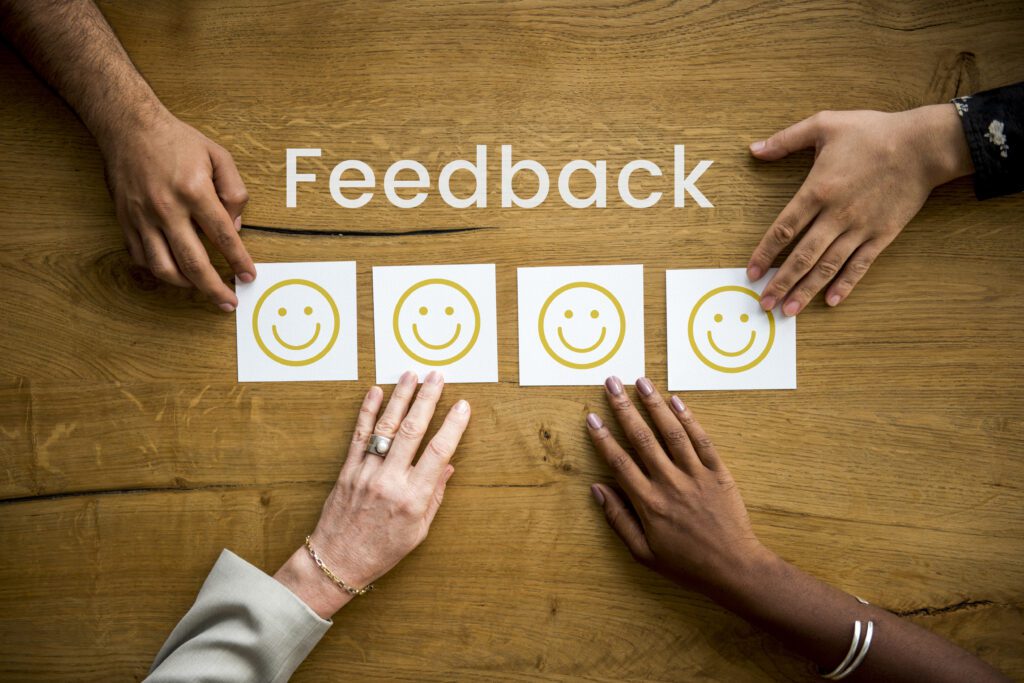 Different people giving feedback by touching their desire emoji on the table