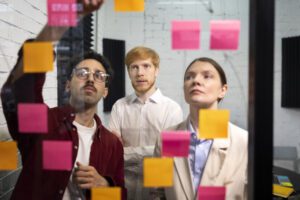 employees dicussing something and pasting sticky notes for better understanding