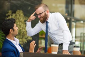 a man screaming on a person sitting on chair due to unhappy service